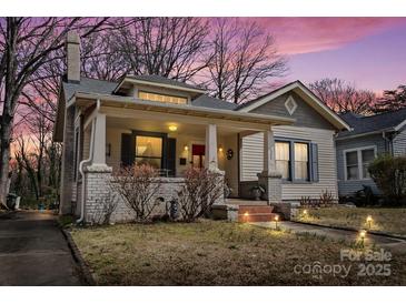 Charming home with a front porch, brick accents, and a well-manicured lawn under a beautiful dusk sky at 524 W Horah St, Salisbury, NC 28144