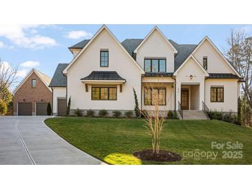 Beautiful brick home with black trim, a manicured lawn, and a concrete driveway at 810 Martingale Ln, Davidson, NC 28036