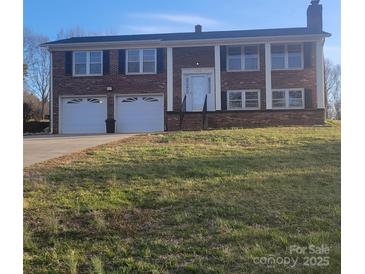 Charming two-story brick home with a well-maintained lawn and a two-car garage, perfect for a Gathering at 1033 College Ave, Shelby, NC 28152