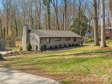 Charming one-story home featuring a brick exterior, well-maintained lawn and mature trees at 1200 Carey Ct, Charlotte, NC 28210