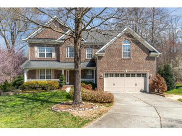 Charming two-story brick home featuring a well-manicured lawn and attached two-car garage at 1347 Lightwood Dr, Matthews, NC 28105