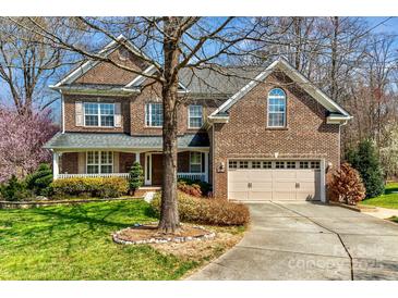 Charming brick home featuring a two-car garage, manicured lawn, and inviting front porch at 1347 Lightwood Dr, Matthews, NC 28105