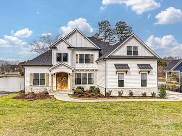 Stunning two-story home with stone accents, a manicured lawn, and charming curb appeal at 144 Morgan Bluff Rd, Mooresville, NC 28117