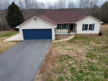 Charming single-story home featuring a blue garage door and a well-maintained lawn and walkway at 155 Rivercliff Dr, Stony Point, NC 28678