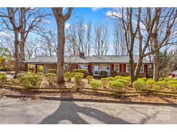 Charming brick home with a cozy covered porch, well-maintained landscaping, and a welcoming front entrance at 424 Virginia Ave, Statesville, NC 28677