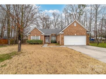 Charming brick home with well-maintained lawn and a welcoming entrance with a white door and attached two-car garage at 6311 Gold Dust Ct, Charlotte, NC 28269