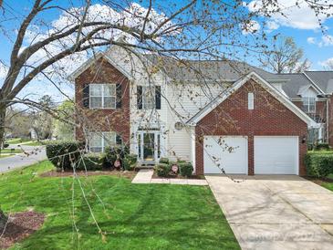 Charming two-story home featuring a manicured front lawn, brick accents, and a two-car garage at 8620 Grey Squirrel Ct, Charlotte, NC 28277