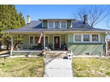 Charming home featuring a covered front porch, American flag, and walkway to the front door at 1025 Old Us 80 Hwy, Gold Hill, NC 28071