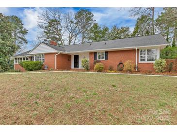 Charming red brick home featuring a well-maintained lawn and colorful landscaping at 1101 Roundknob Ave, Salisbury, NC 28144