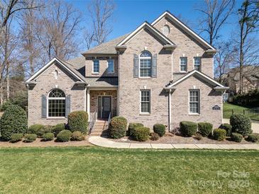 Charming two-story brick home with a well-manicured lawn and mature landscaping at 11243 Home Place Ln, Mint Hill, NC 28227