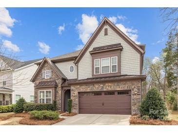 Charming two-story home boasts stone accents, a two-car garage, and a well-manicured front yard at 13725 Laughing Gull Dr, Charlotte, NC 28278
