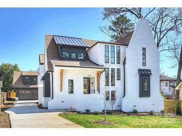Stunning exterior of a brick home featuring modern design elements and manicured landscaping under a clear blue sky at 2325 Winthrop Ave, Charlotte, NC 28203