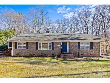 Charming brick home with well-maintained lawn, blue front door and dark shutters for a traditional feel at 2913 Archdale Dr, Charlotte, NC 28210