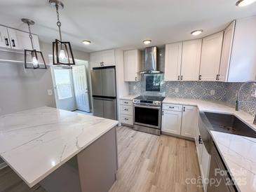 Modern kitchen features stainless steel appliances, stylish backsplash, and a spacious island with a quartz countertop at 7812 Highbanks Ct, Charlotte, NC 28212