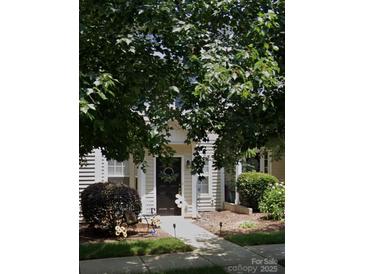 Charming home exterior showcasing a wreath-adorned front door and beautifully landscaped yard at 10438 Trolley Run Dr, Cornelius, NC 28031