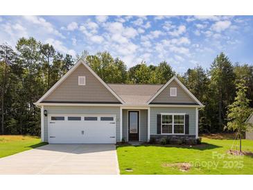 Charming single-story home featuring a two-car garage, stone accents, and a well-manicured lawn at 111 Tradesmen Trl # 75, Troutman, NC 28166