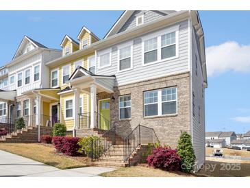 Charming townhome showcasing a brick facade, light gray siding, and vibrant green front door at 12461 Bryton Ridge Pkwy, Huntersville, NC 28078