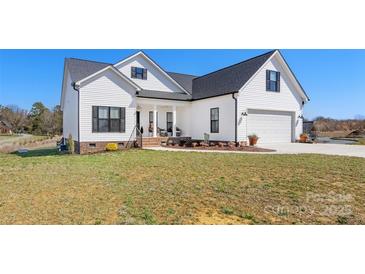 Charming two-story home with white siding, black shutters and a well-manicured lawn at 1323 Stack Rd, Monroe, NC 28112