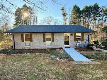 Charming single-story home with brick facade, wooden shutters, and a well-maintained front yard at 134 Weaver Hill Dr, Statesville, NC 28625