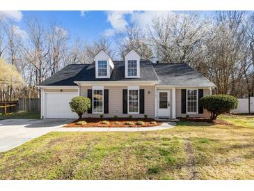 Charming one-story home with a manicured lawn, dormer windows, and attached garage at 13701 Dawlish Ln, Pineville, NC 28134