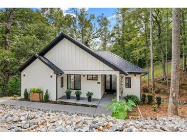 Inviting front exterior of home with black roof, black trim, welcome sign, and rock landscaping at 231 Sunny Path Ln, Statesville, NC 28677