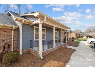Charming townhome displaying a covered front porch and brick foundation with impeccable curb appeal at 234 Pointe Cir, Rock Hill, SC 29732