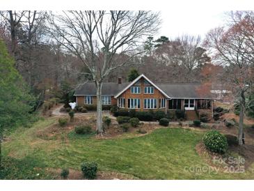 Charming brick home with a well-maintained lawn and mature trees, creating a picturesque setting at 2818 Cherry Ln, Denver, NC 28037