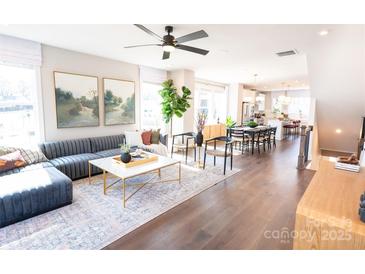 Bright open-concept living room features modern decor, stylish furniture, and seamless flow to the kitchen and dining area at 305 Old Town Village Rd, Waxhaw, NC 28173