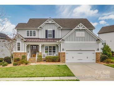 Charming two-story home featuring a well-manicured lawn, stone accents and a two car garage at 5431 Meadowcroft Way, Fort Mill, SC 29708