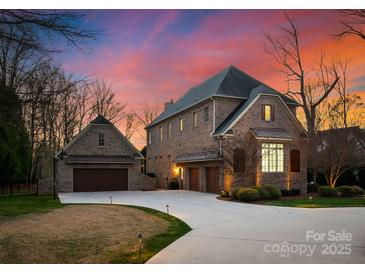Stunning brick home featuring an attached three car garage and a circular driveway at 5824 Preston Ln, Charlotte, NC 28270