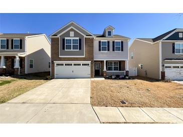 Charming two-story home featuring a two-car garage and a welcoming front porch at 9025 Remnick Dr, Gastonia, NC 28056