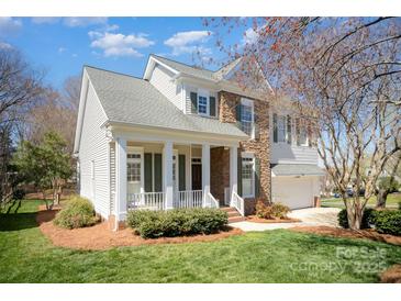 Charming two-story home with a stone facade, a well-manicured lawn and a cozy front porch at 10502 Orchid Hill Ln, Charlotte, NC 28277