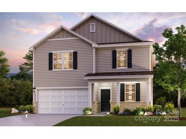 Charming two-story home showcasing a manicured lawn, a two-car garage, and a covered front porch at 557 Mountain View Dr, Monroe, NC 28110