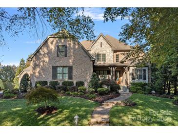 Inviting two-story brick home featuring stone accents and a manicured front yard, exuding curb appeal at 8724 Highgrove St, Charlotte, NC 28277