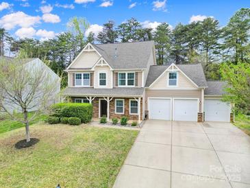 Charming two-story home with neutral siding, stone accents, manicured lawn, and a three car garage at 1122 Hartmann Ct, Fort Mill, SC 29715