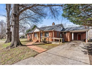 Charming brick home featuring a covered porch, convenient carport, and inviting brick walkway at 1407 17Th Ne Ave, Hickory, NC 28601