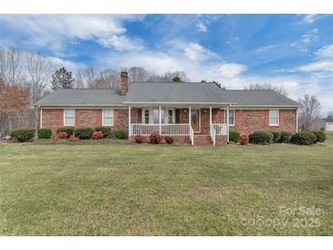 Charming brick home with a covered front porch and beautifully maintained lawn and garden at 218 Countryside Rd, Kings Mountain, NC 28086