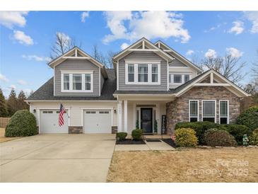 Charming two-story home boasts a two-car garage, stone accents and manicured landscaping at 3549 Sandy E Trl, Fort Mill, SC 29707