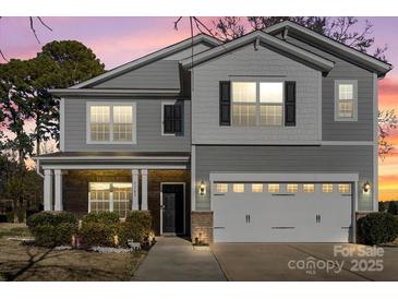 Charming two-story home with a well-manicured lawn and a two-car garage at 5703 Eleanor Rigby Rd, Charlotte, NC 28278