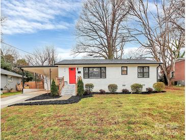 Charming single-story home with white brick exterior, bright red front door, and well-manicured landscaping at 914 Crestmere St, Charlotte, NC 28208