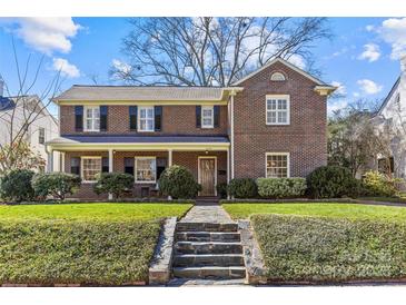 Charming two-story brick home with a well-manicured lawn and a stone pathway leading to the front door at 1626 Beverly Dr, Charlotte, NC 28207
