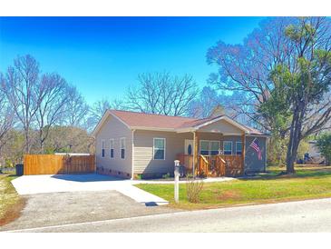 Charming single-story home with a wooden porch, landscaped yard, and a clear blue sky above at 409 Fourth St, York, SC 29745