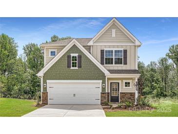 Charming two-story home featuring a two-car garage, stone accents, and manicured lawn at 4465 Dusty Orchard Rd, Kannapolis, NC 28081