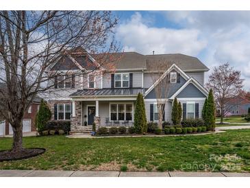 Charming two-story home with a well-manicured lawn and beautiful landscaping at 8941 Vickery Ln, Harrisburg, NC 28075