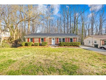 Traditional brick home with red shutters, showcasing a neat front yard and mature trees at 1203 Northwoods Dr, Kings Mountain, NC 28086