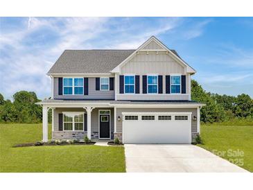 Charming two-story home with a two-car garage, landscaped yard, and inviting front porch at 1240 Cottage Green Dr # 0132, Monroe, NC 28112
