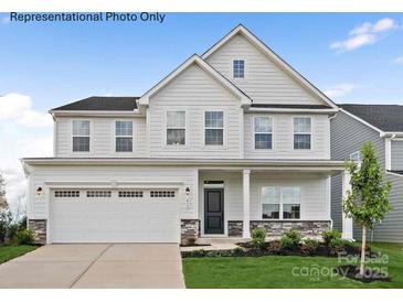 Beautiful two-story home featuring stone accents, a two-car garage and manicured landscaping at 3022 Bramble Hedge Rd # 3269, Indian Trail, NC 28079