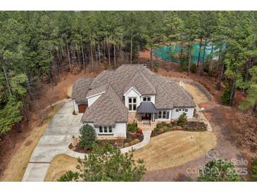 Stunning aerial view of home on a wooded lot with a tranquil pond at 4009 Beechwood Spring Ln, Belmont, NC 28012