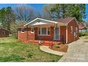 Charming brick home featuring a quaint, covered front porch with a wrought iron railing at 602 Dallas Spencer Mountain Rd, Dallas, NC 28034