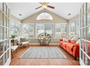 Bright sunroom with hardwood floors, lots of windows, vaulted ceilings, and a cozy seating arrangement at 824 Wynnshire Dr # D, Hickory, NC 28601